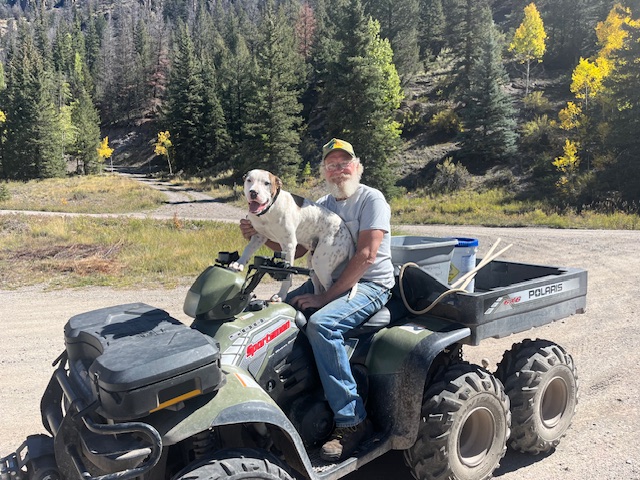 man on OHV with dog